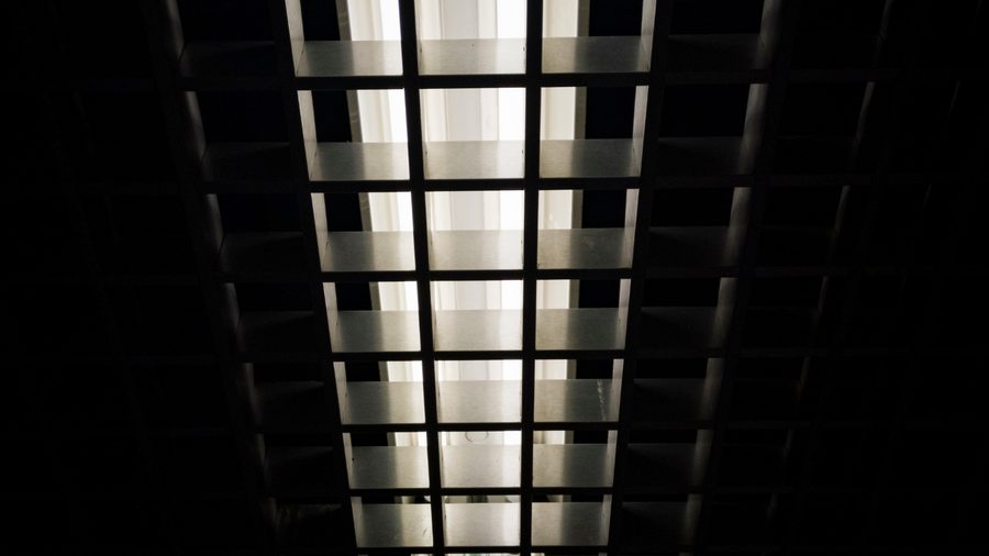 Looking up at a commercial ceiling light grid with fluorescent fixtures